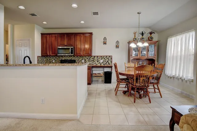 a view of a dining room with furniture and a chandelier