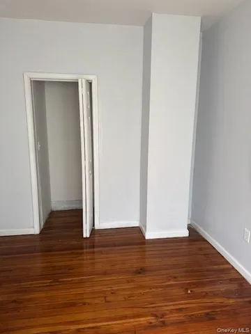 an empty room with wooden floor and closet