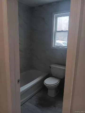 a bathroom with a toilet a sink and a window