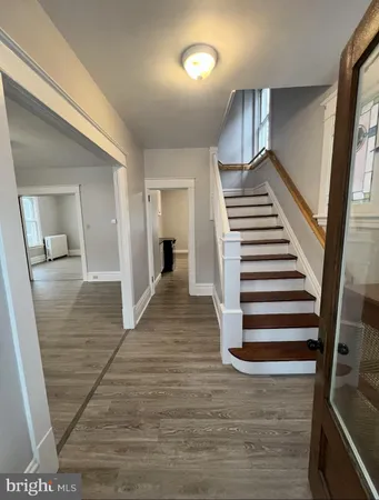 a view of a hallway with wooden floor and stairs