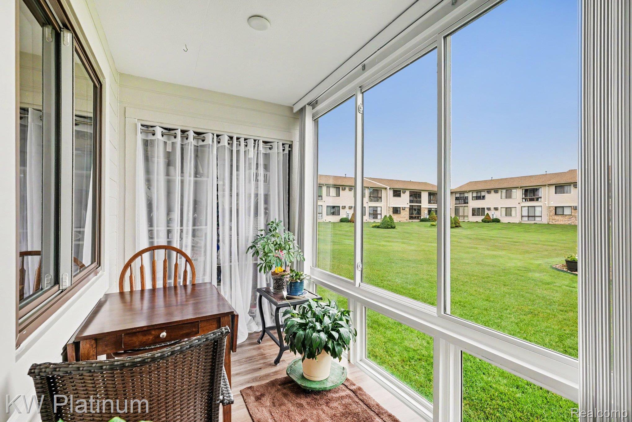 1700 River Road, Unit 6 Marysville, MI 48040 - Photo 13 of 32 Enclosed patio featuring floor-to-ceiling windows, white trim, and wood-finish flooring