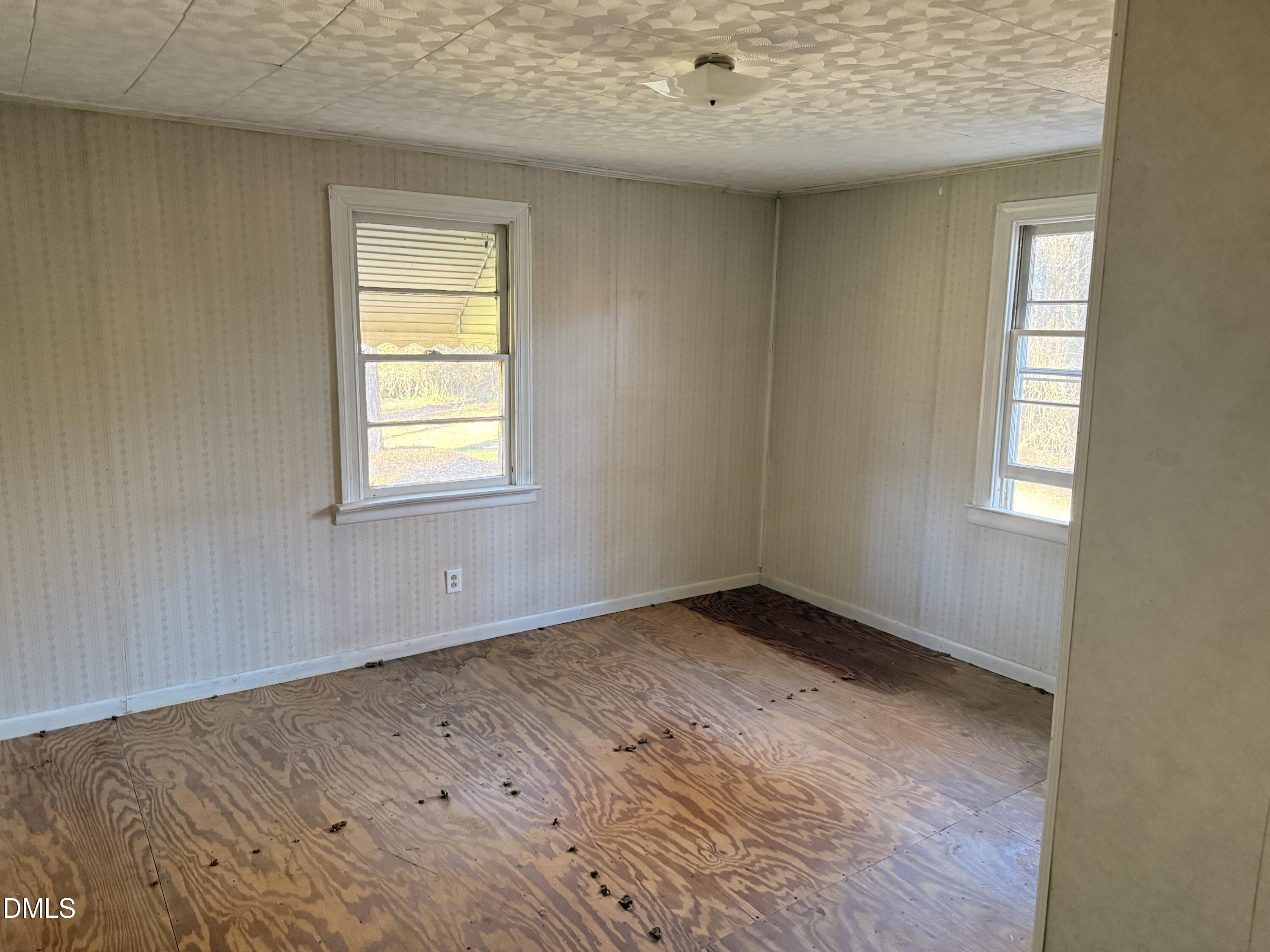 8066 Springfield School Road Kenly, NC 27542 - Photo 10 of 11 an empty room with wooden floor and windows