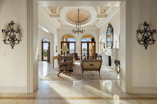 a living room with furniture a chandelier and a fireplace