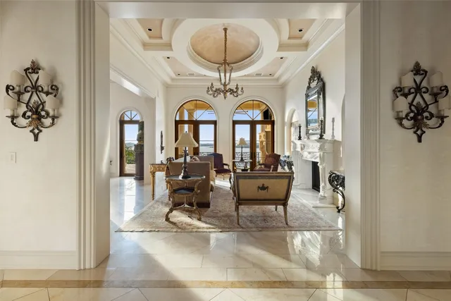a living room with furniture a chandelier and a fireplace