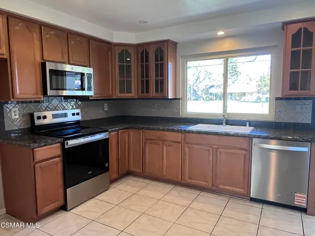 a kitchen with stainless steel appliances granite countertop a stove sink and microwave