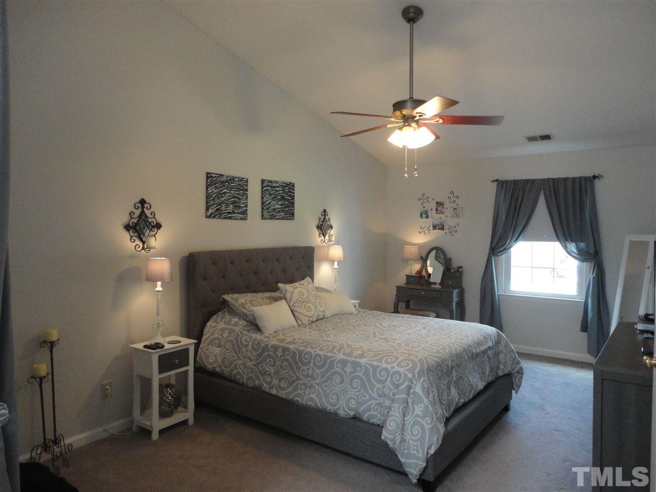 2369 Declaration Drive Raleigh, NC 27615 - Photo 12 of 20 a bedroom with a bed and a chandelier