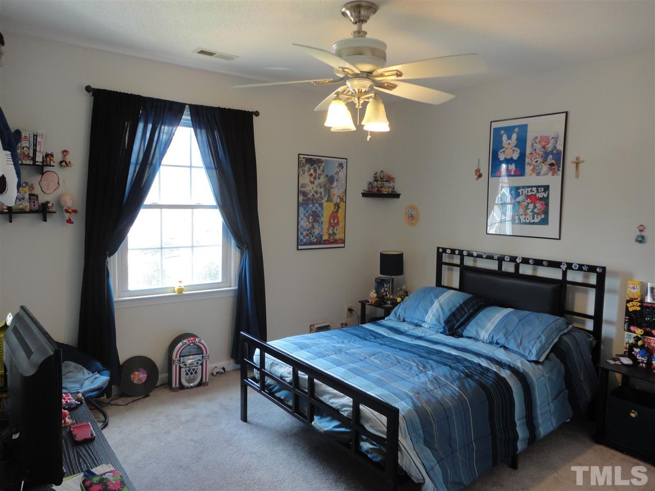 2369 Declaration Drive Raleigh, NC 27615 - Photo 16 of 20 a bedroom with a bed and a chandelier