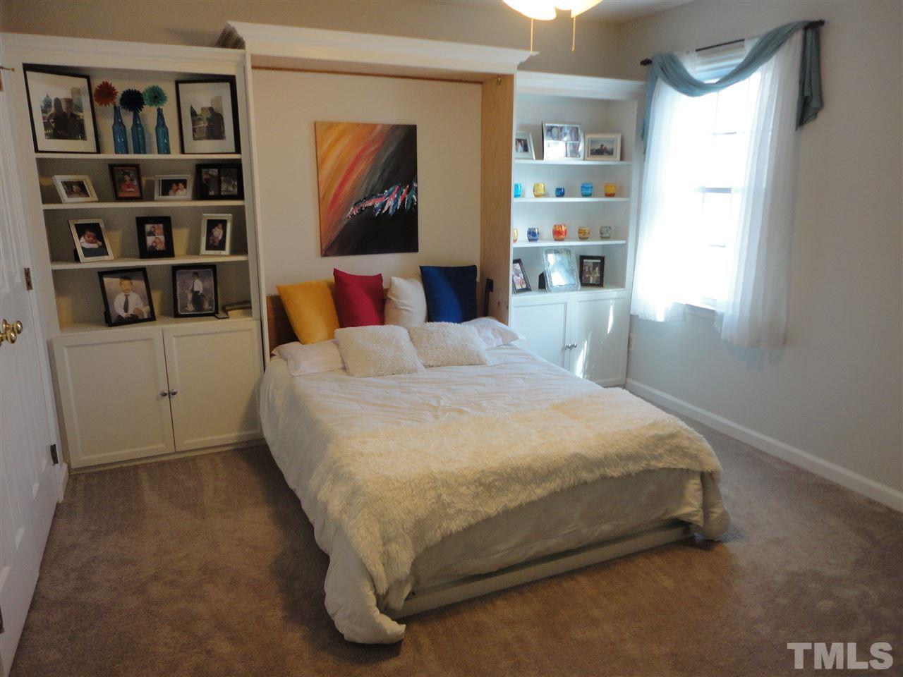 2369 Declaration Drive Raleigh, NC 27615 - Photo 19 of 20 a bed sitting in a bedroom next to a book shelf