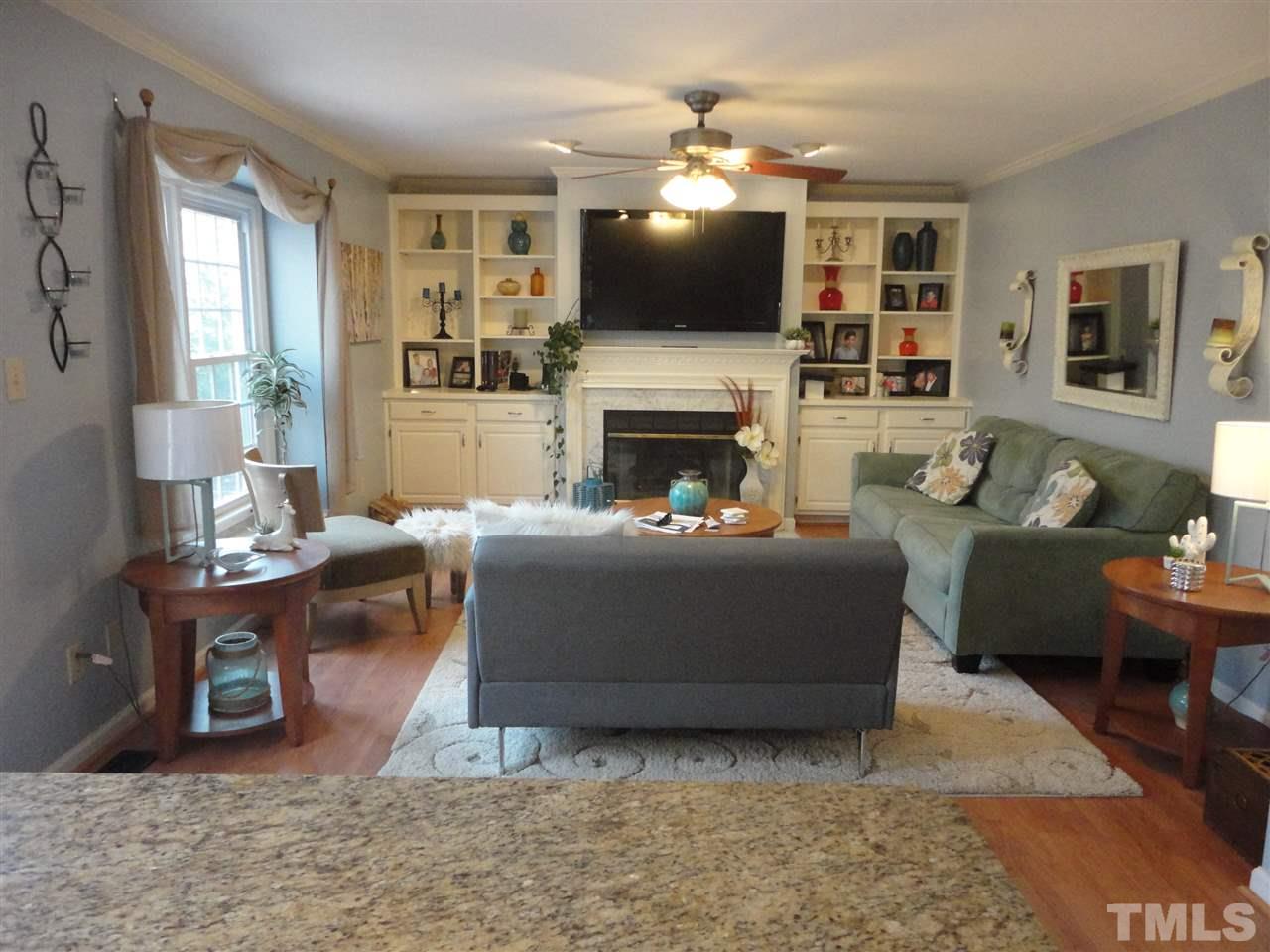 2369 Declaration Drive Raleigh, NC 27615 - Photo 7 of 20 a living room with furniture a fireplace and a flat screen tv