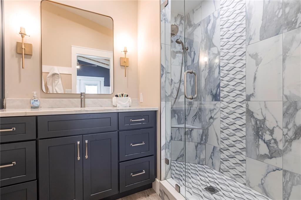 6020 Midnight Pass Road, Unit 39 Sarasota, FL 34242 - Photo 13 of 19 a bathroom with a granite countertop sink a vanity and a mirror