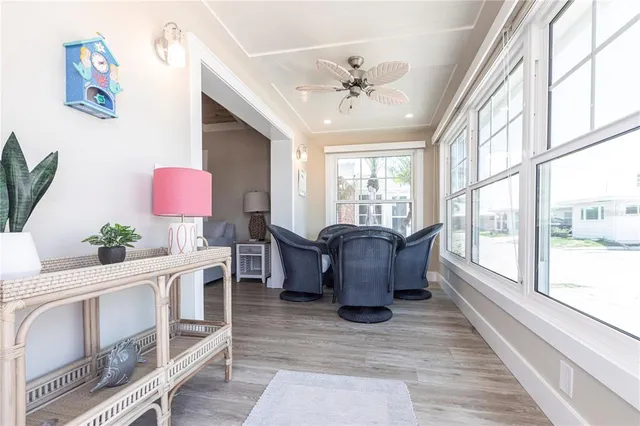 a living room with furniture large window and wooden floor