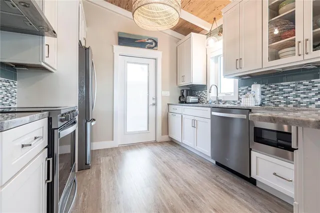 a kitchen with stainless steel appliances granite countertop a stove a sink and a microwave