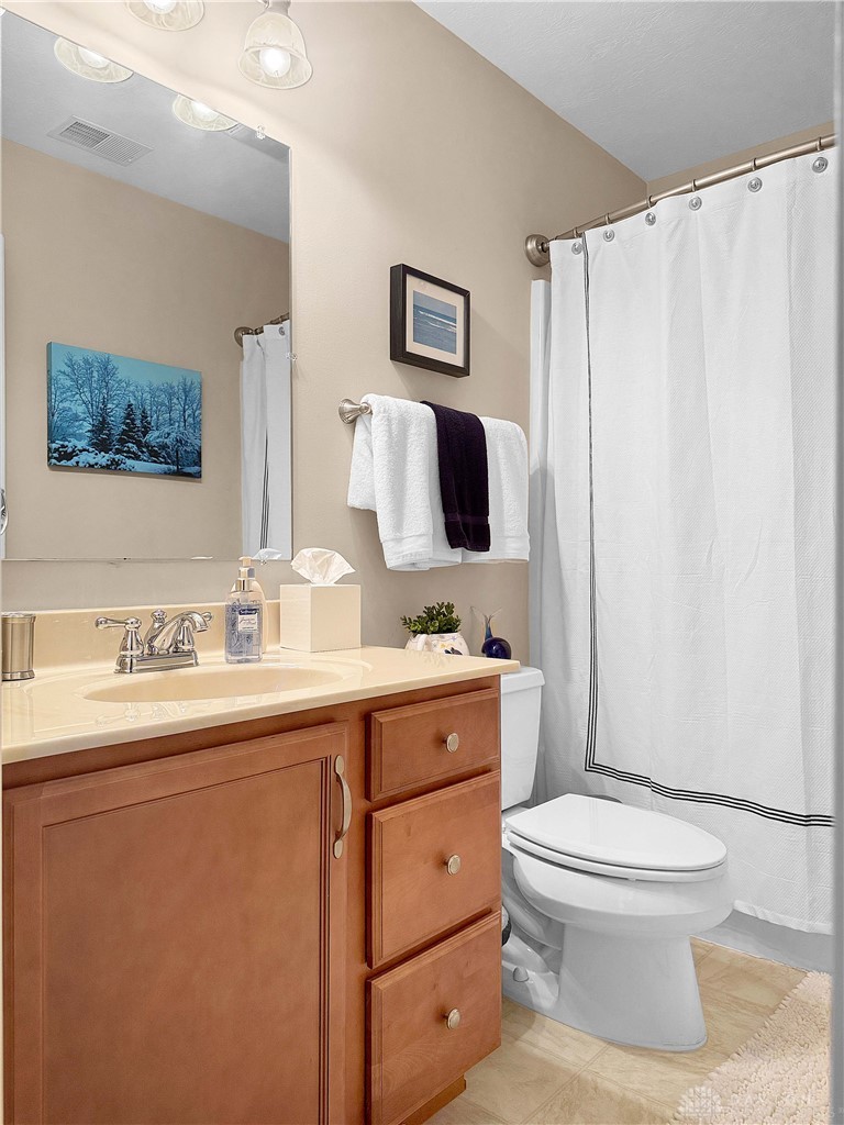 4096 Middle Urbana Road Urbana, OH 43078 - Photo 7 of 96 This bathroom features a sleek vanity, mirror, and a convenient shower with a privacy curtain.
