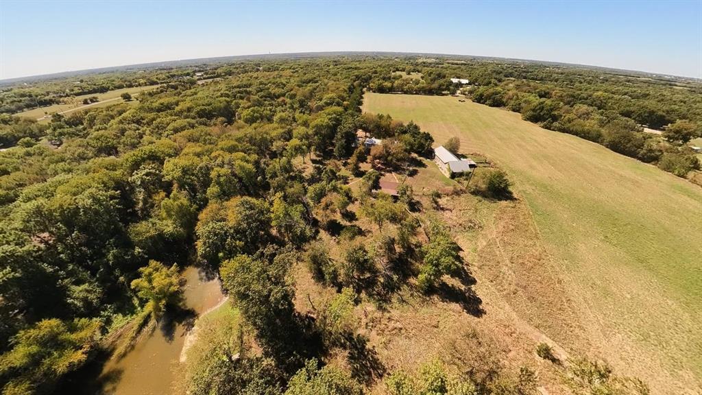 242 Oak Hill Road Van Alstyne, TX 75495 - Photo 7 of 10 Expansive acreage featuring a body of water, mature tree coverage, open fields, and a barn structure
