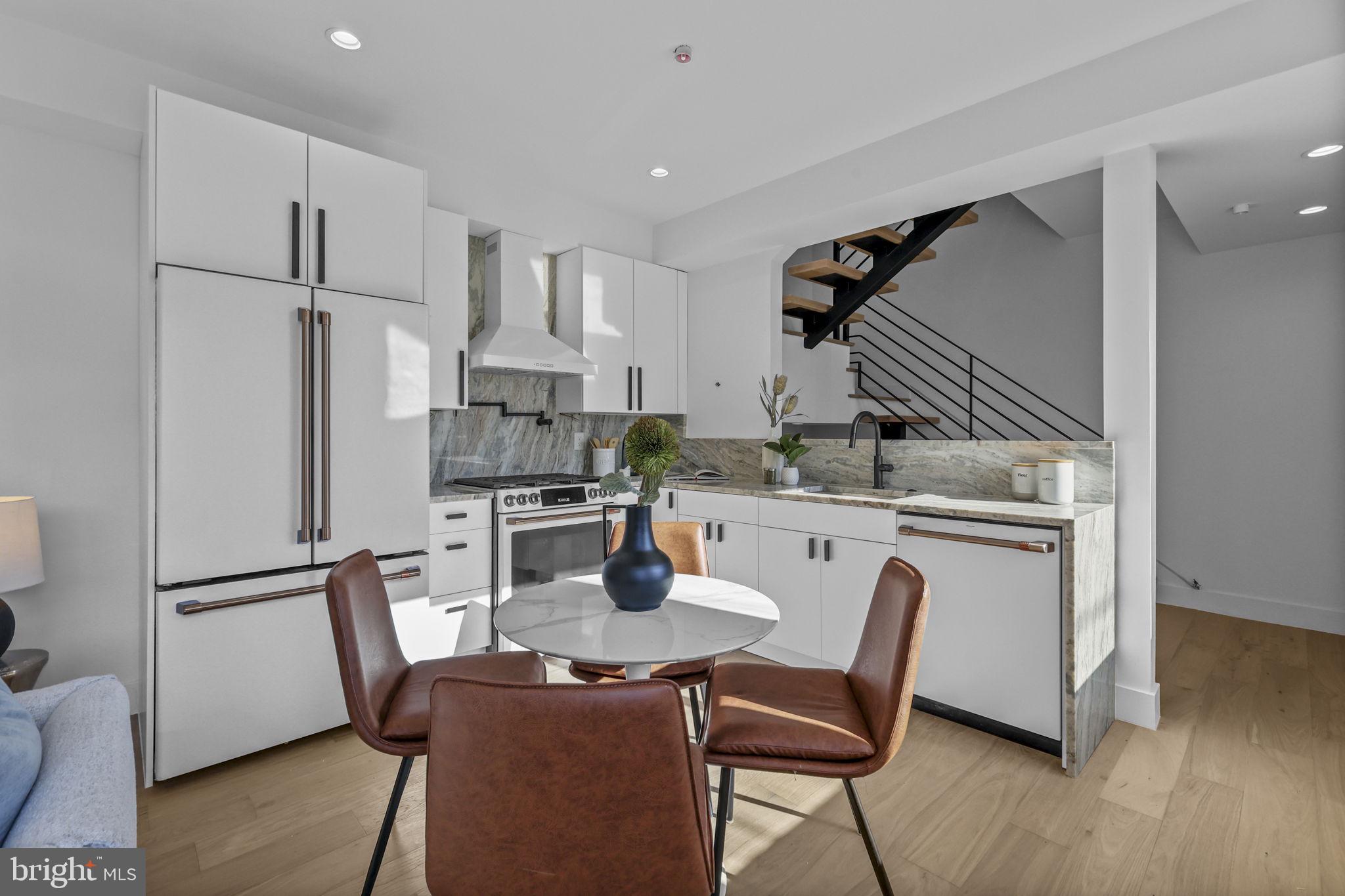 514 South 20th Street, Unit B Philadelphia, PA 19146 - Photo 2 of 52 a kitchen with stainless steel appliances granite countertop a dining table chairs refrigerator and sink