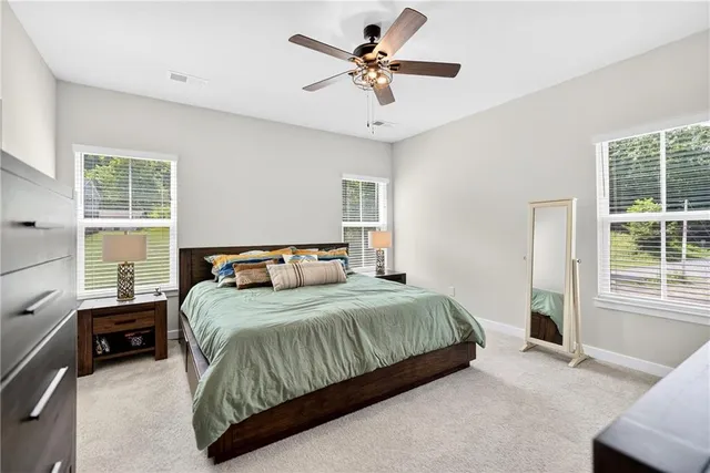 a bedroom with a large bed and a chandelier