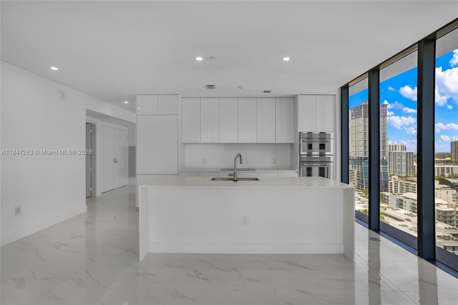 700 Northeast 24th Street, Unit 2101 Miami, FL 33137 - Photo 22 of 100 a large white kitchen with wooden floor and a sink