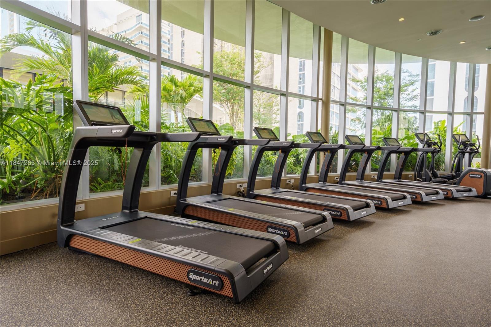 700 Northeast 24th Street, Unit 2101 Miami, FL 33137 - Photo 96 of 100 a room with gym equipment and large windows