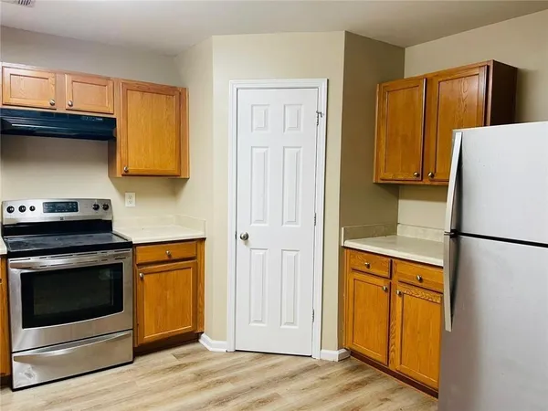 a white refrigerator freezer and a stove sitting inside of a kitchen