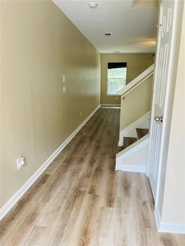 a view of a big room with wooden floor and staircase