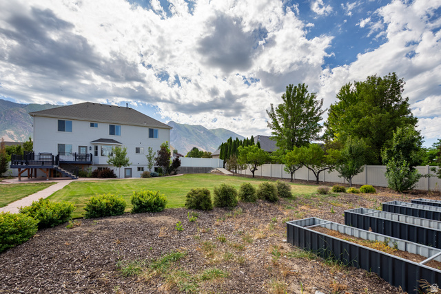 868 Braddock Lane Alpine, UT 84004 - Photo 59 of 64 Expansive backyard featuring a large green lawn, mature trees, and a concrete paver pathway
