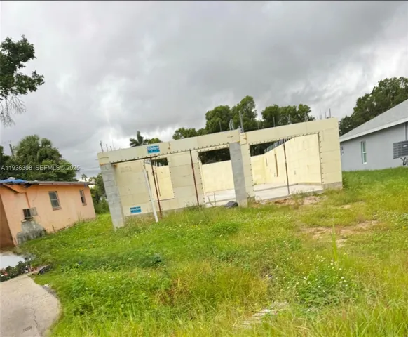 a view of a white house with a big yard and large trees