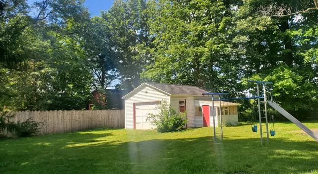 a view of a house with a backyard and a tree