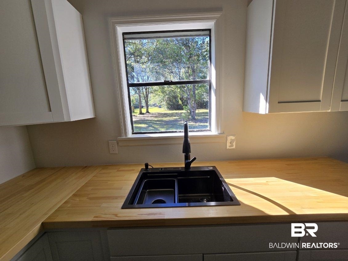 1404 Dailey Street Brewton, AL 36426 - Photo 10 of 25 Kitchen featuring white cabinets and butcher block countertops