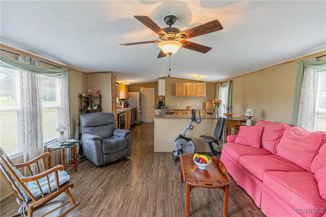 a living room with furniture kitchen view and a large window