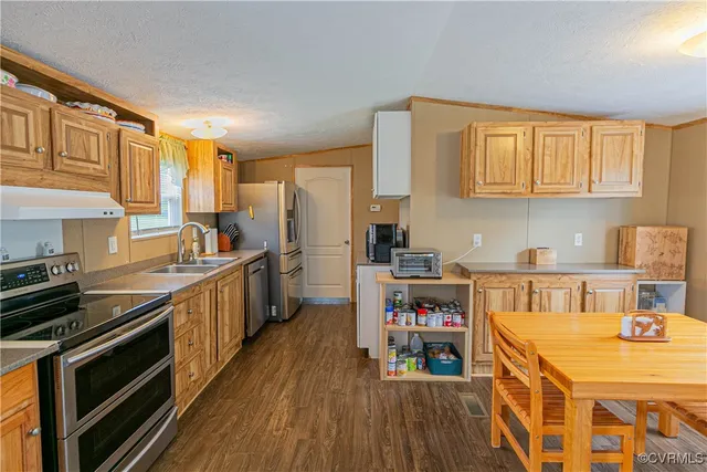 a kitchen with a table chairs stove and wooden floor
