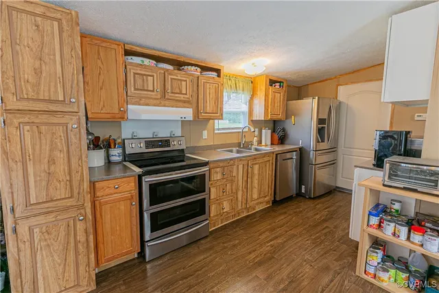 a kitchen with stainless steel appliances granite countertop a stove a sink dishwasher and a refrigerator