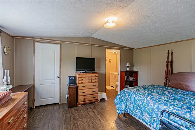 a bedroom with a bed and a flat tv screen on a dresser