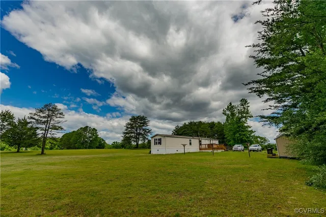 a front view of a house with a garden and trees