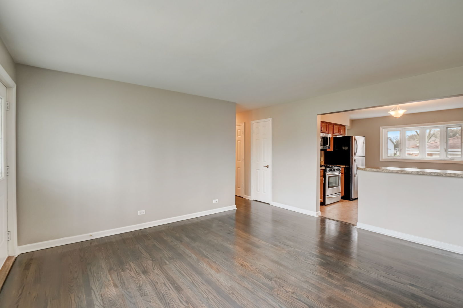3132 Willow Road South Chicago Heights, IL 60411 - Photo 5 of 26 a view of an empty room with wooden floor and a kitchen