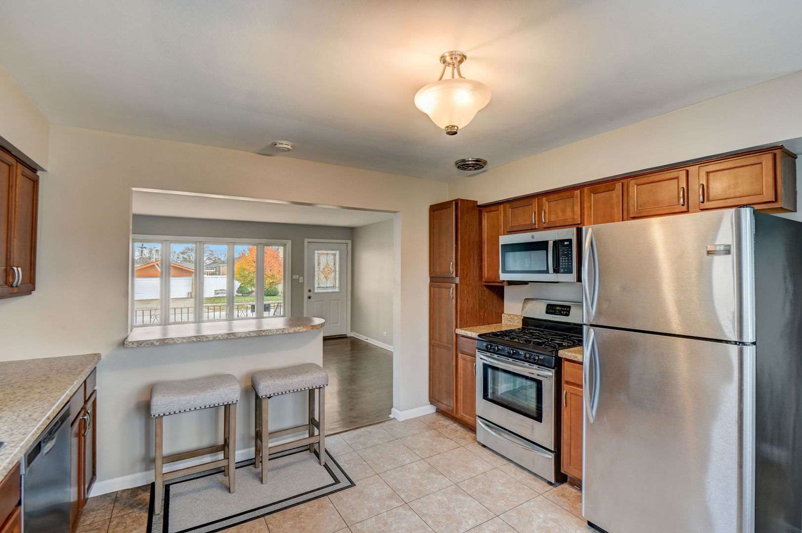 3132 Willow Road South Chicago Heights, IL 60411 - Photo 8 of 26 a kitchen with stainless steel appliances granite countertop a refrigerator a stove a sink dishwasher a dining table and chairs with wooden floor