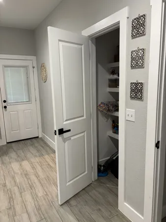 a view of a hallway with wooden floor and closet