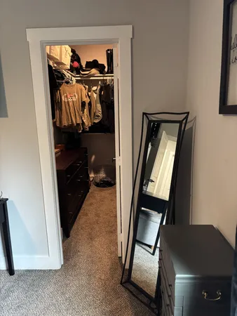 a view of walk in closet with clothes and shoes