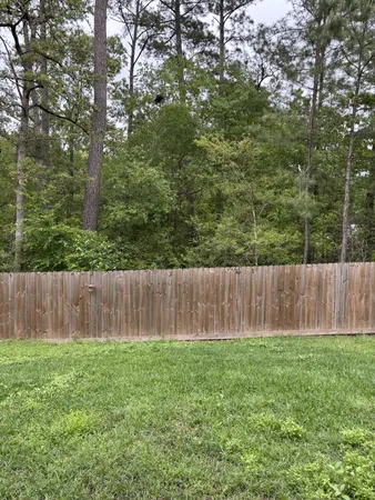 a view of backyard with wooden fence