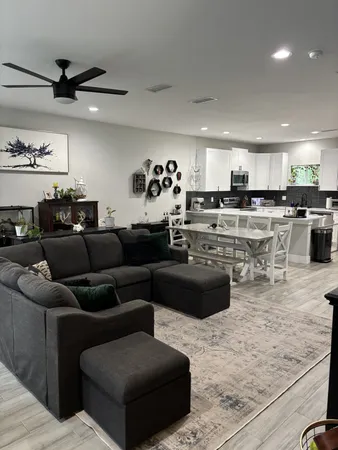 a living room with lots of furniture and kitchen view