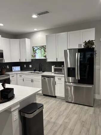 a kitchen with granite countertop a refrigerator stove top oven and sink