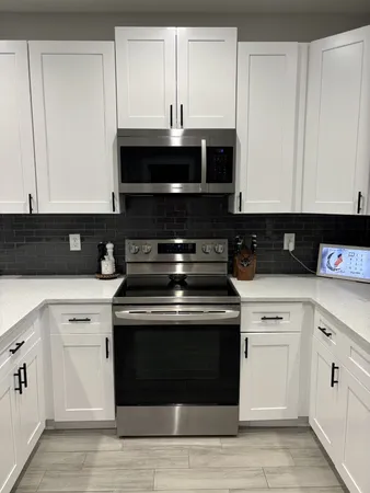 a kitchen with stainless steel appliances granite countertop a stove and a microwave