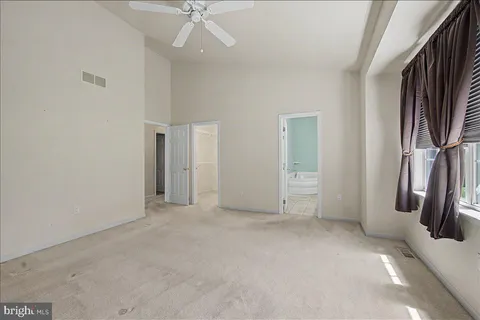 an empty room with closet and a ceiling fan