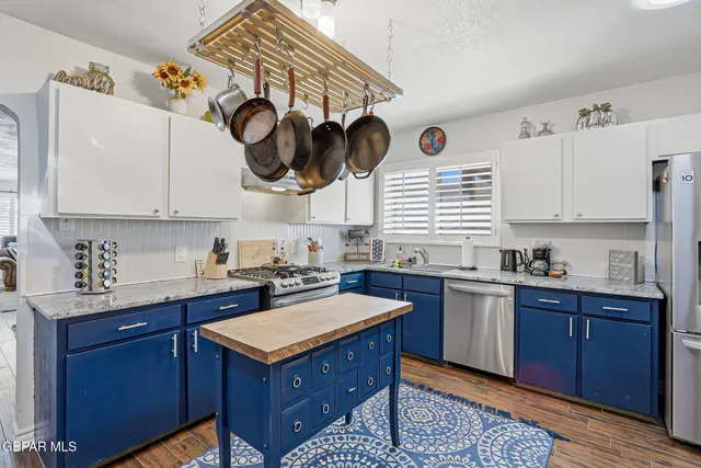 a kitchen with stainless steel appliances granite countertop a sink a stove and cabinets