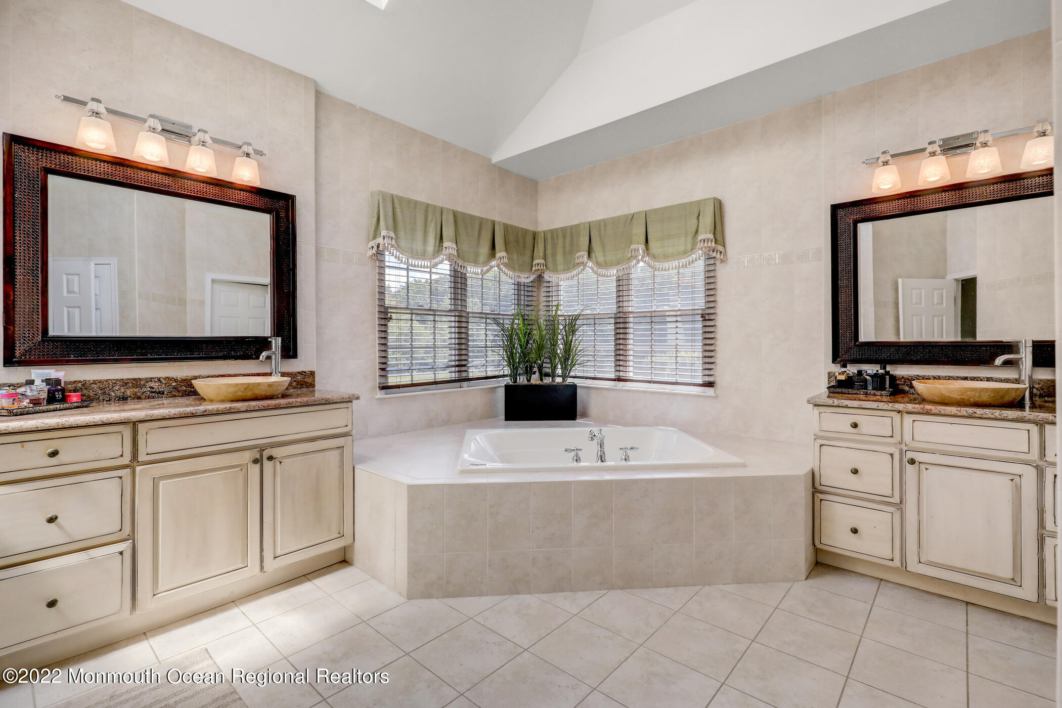 19 Rockingham Court Manalapan, NJ 07726 - Photo 32 of 52 a bathroom with a double vanity sink a mirror and a bathtub
