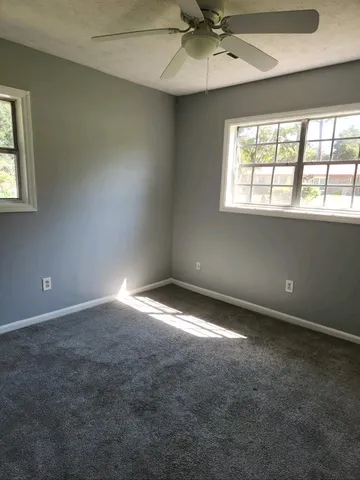an empty room with windows and closet