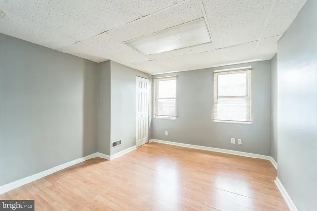 a view of empty room with wooden floor