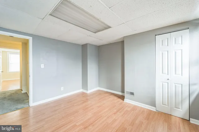 a view of empty room with wooden floor