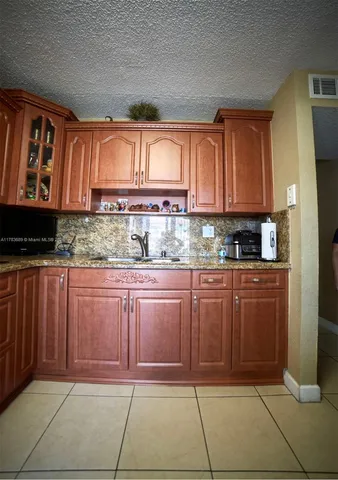 a kitchen with stainless steel appliances granite countertop a refrigerator and cabinets