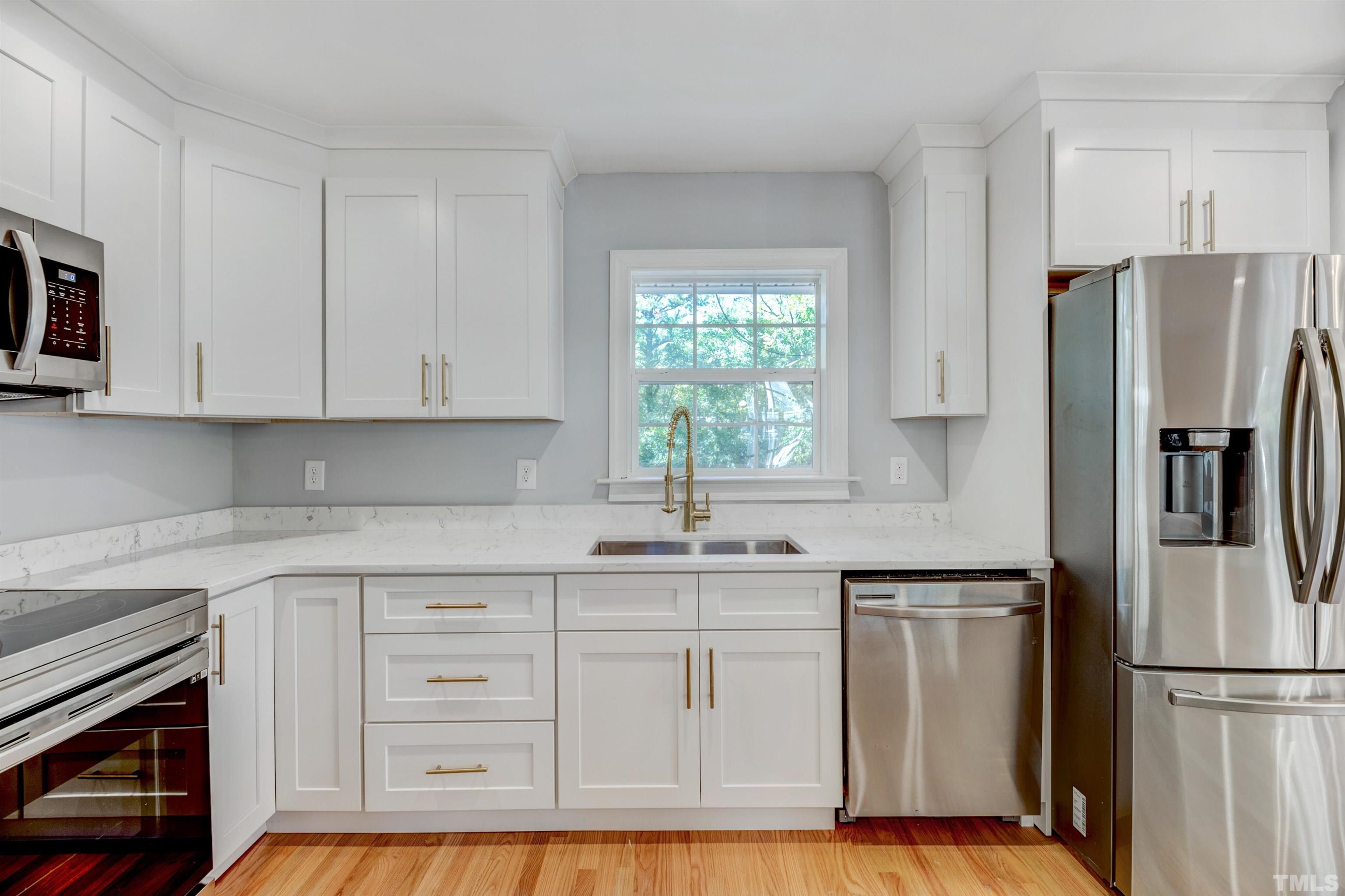 618 Starmont Drive Durham, NC 27705 - Photo 14 of 45 a kitchen with white cabinets stainless steel appliances and a sink