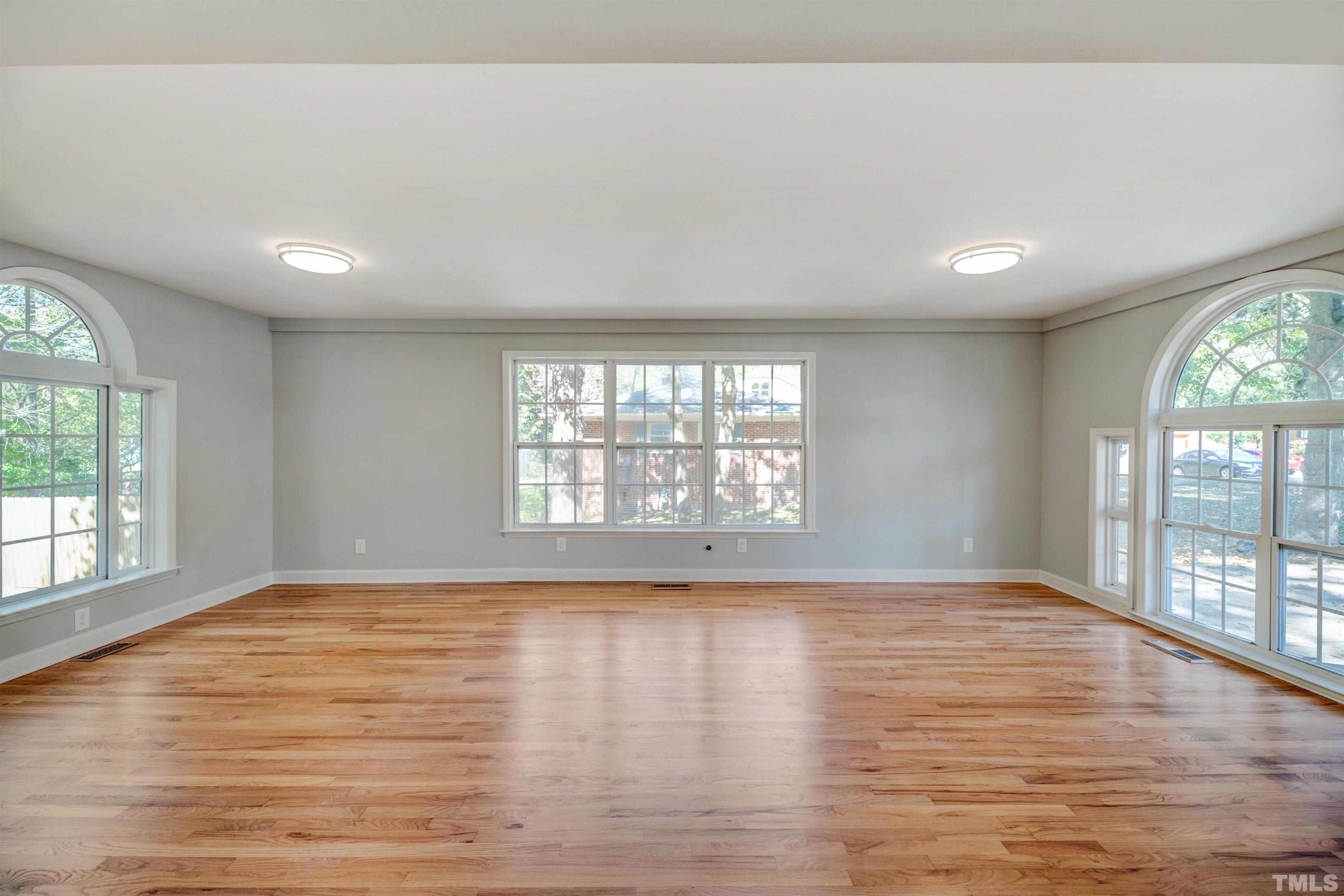 618 Starmont Drive Durham, NC 27705 - Photo 18 of 45 an empty room with wooden floor and windows